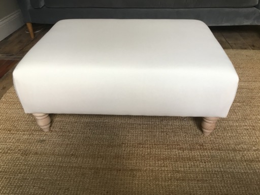 A footstool upholstered in plain calico, before its top cover goes on
